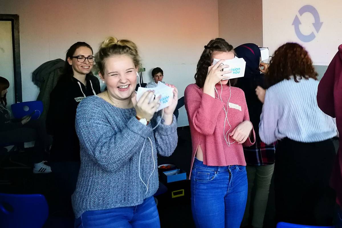 Zwei Schülerinnen testen VR-Brillen von visionYOU und lachen gemeinsam.