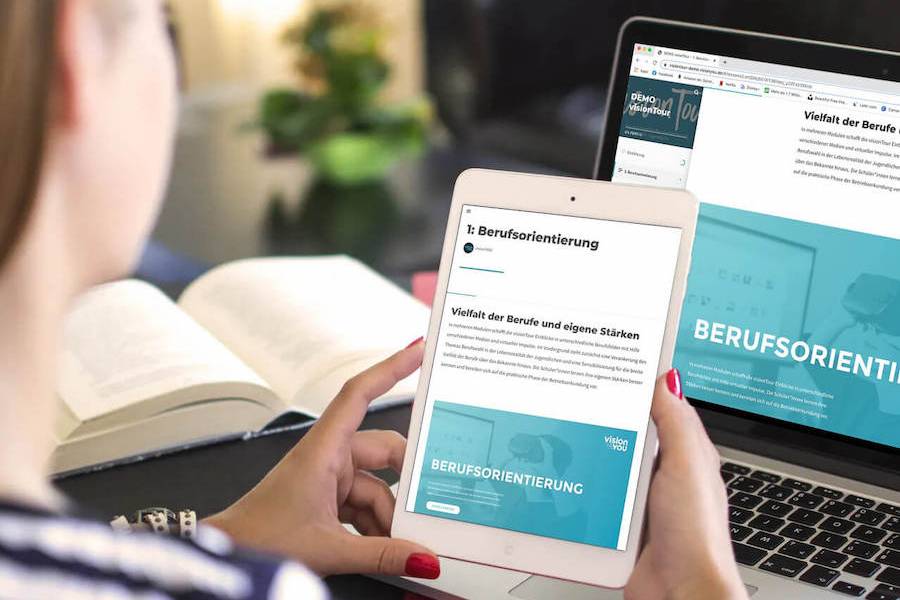Person betrachtet auf Tablet und Laptop ein Modul der 