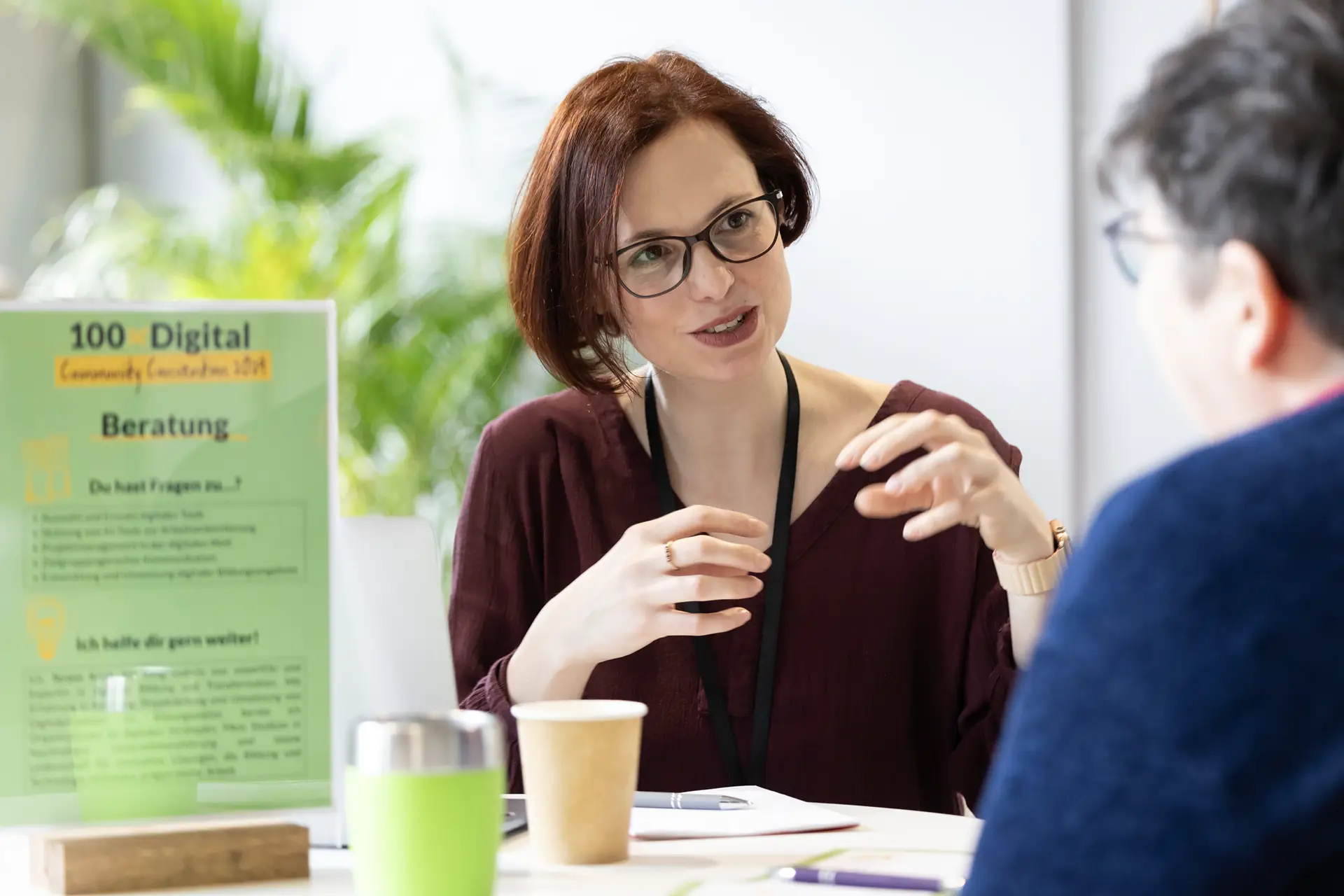 Beraterin im Gespräch mit einer teilnehmenden Person bei einer 100xDigital-Veranstaltung.